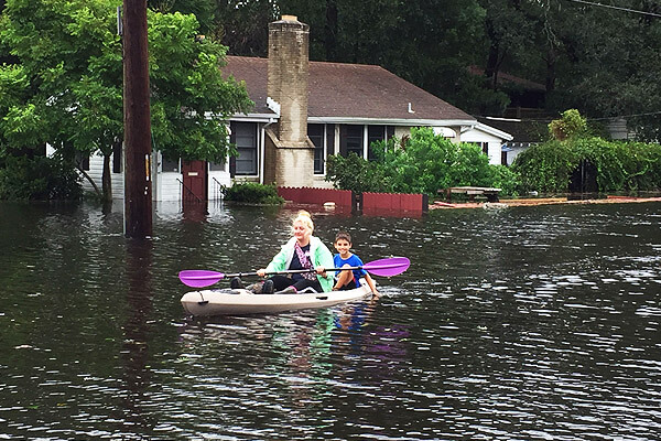 devastated residents canoe down flooded street